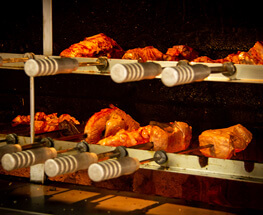 Imagem ilustrativa de um churrasco bem suculento dentro da churrasqueira